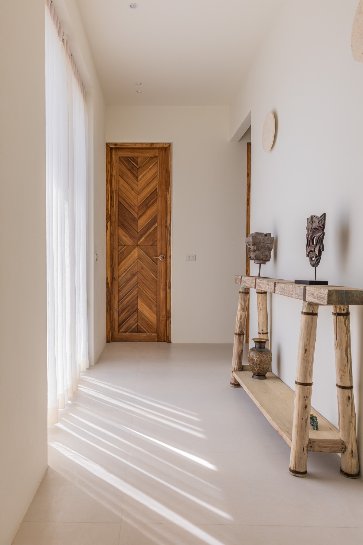 Sunlit hallway with teak door